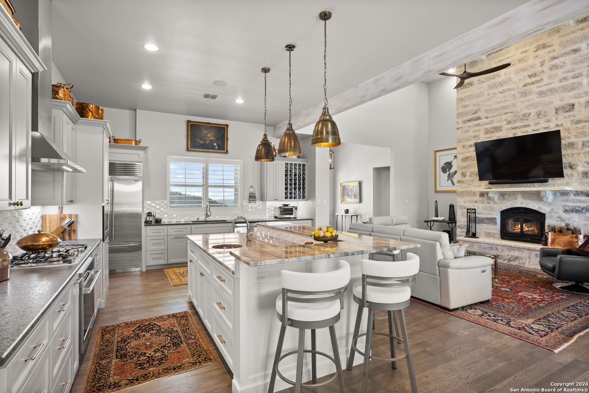 Fireplace, Interior, Kitchen, Living room, Pendant Lights, Recessed Lighting, Stainless Steel Appliances, Stone Walls, Wood Texture Flooring