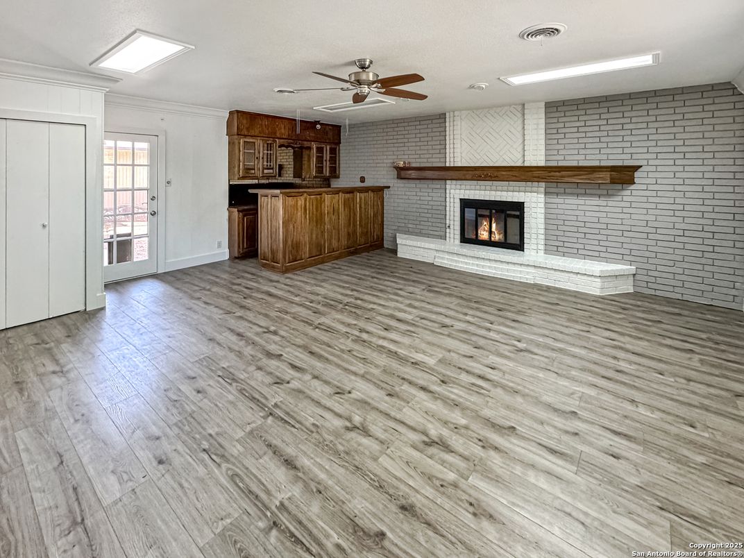 Empty room, Fireplace, Interior, Kitchen, Recessed Lighting, Stone Walls, Wood Texture Flooring