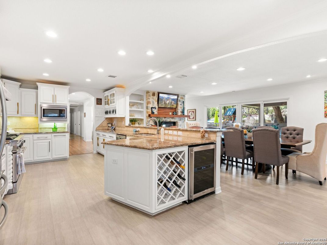 Dining room, Fireplace, Interior, Kitchen, Recessed Lighting, Stainless Steel Appliances, Wood Texture Flooring