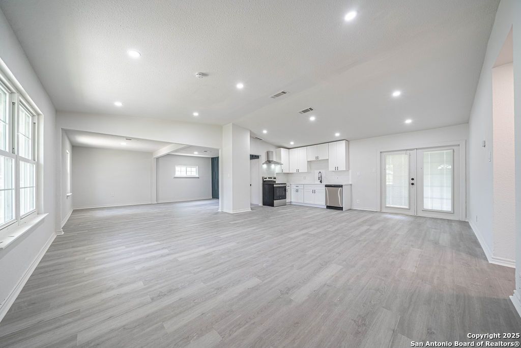 Empty room, Interior, Kitchen, Recessed Lighting, Stainless Steel Appliances, Wood Texture Flooring