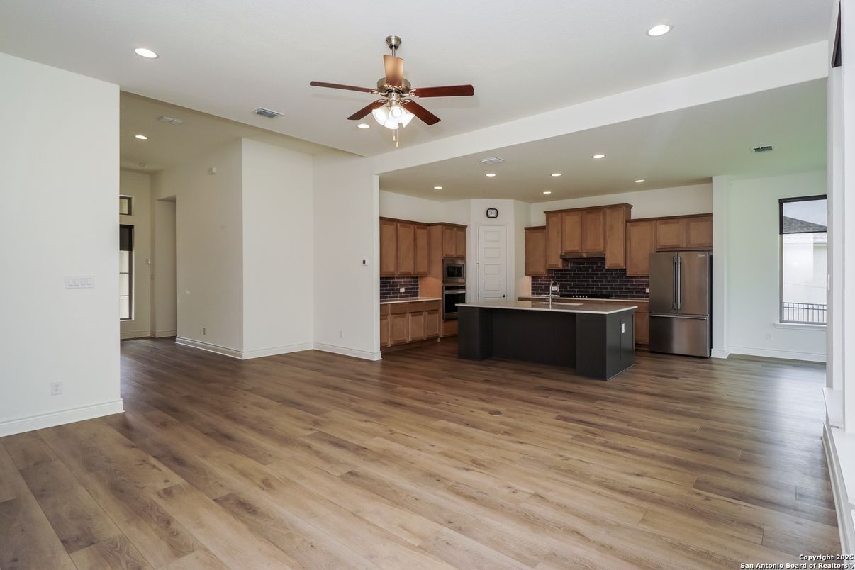Empty room, Interior, Kitchen, Recessed Lighting, Stainless Steel Appliances, Wood Texture Flooring