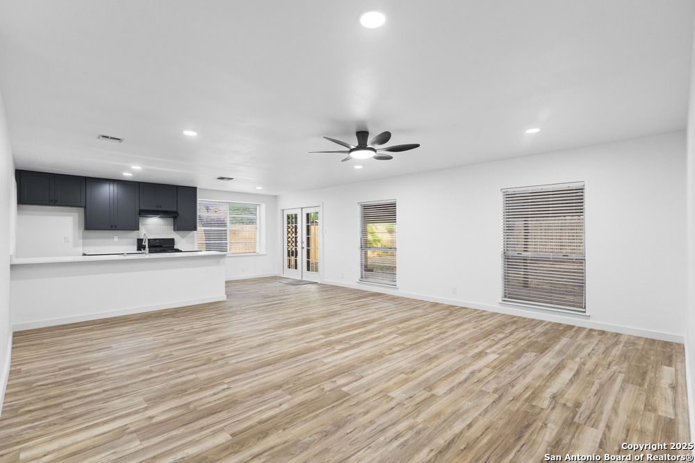 Empty room, Interior, Kitchen, Recessed Lighting, Stainless Steel Appliances, Wood Texture Flooring