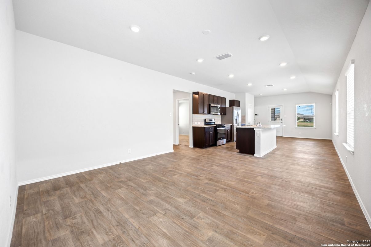 Empty room, Interior, Kitchen, Recessed Lighting, Stainless Steel Appliances, Wood Texture Flooring