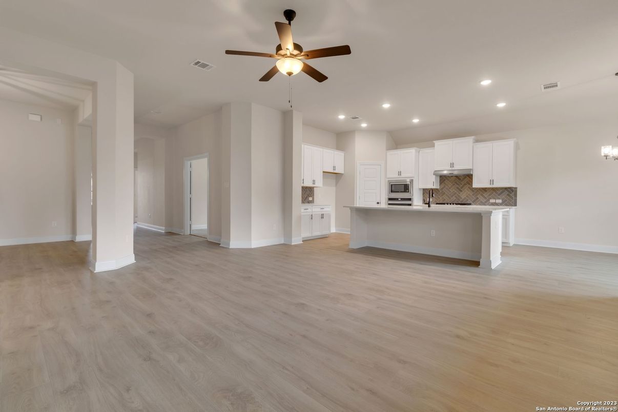 Empty room, Interior, Kitchen, Recessed Lighting, Stainless Steel Appliances, Wood Texture Flooring