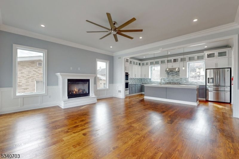 Empty room, Fireplace, Interior, Kitchen, Pendant Lights, Recessed Lighting, Stainless Steel Appliances, Wood Texture Flooring
