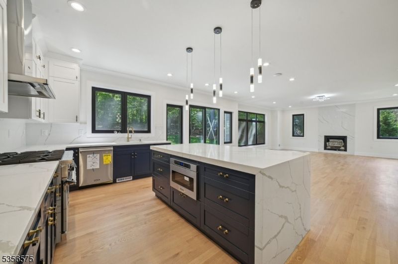 Fireplace, Interior, Kitchen, Marble Walls, Pendant Lights, Recessed Lighting, Stainless Steel Appliances, Wood Texture Flooring