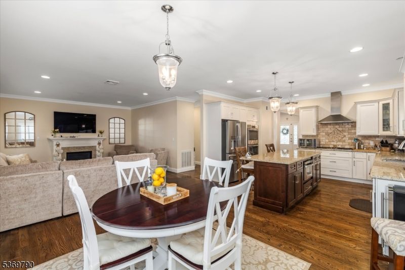 Dining room, Fireplace, Interior, Kitchen, Living room, Pendant Lights, Recessed Lighting, Stainless Steel Appliances, Wood Texture Flooring