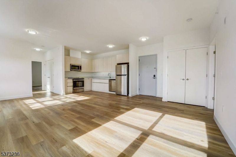 Empty room, Interior, Kitchen, Recessed Lighting, Stainless Steel Appliances, Wood Texture Flooring