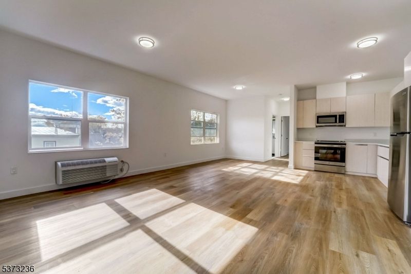 Empty room, Interior, Kitchen, Recessed Lighting, Stainless Steel Appliances, Wood Texture Flooring