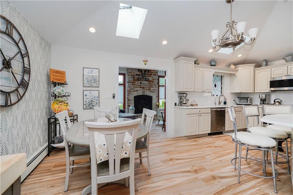 Chandelier, Dining room, Fireplace, Interior, Kitchen, Pendant Lights, Recessed Lighting, Stainless Steel Appliances, Stone Walls, Wood Texture Flooring