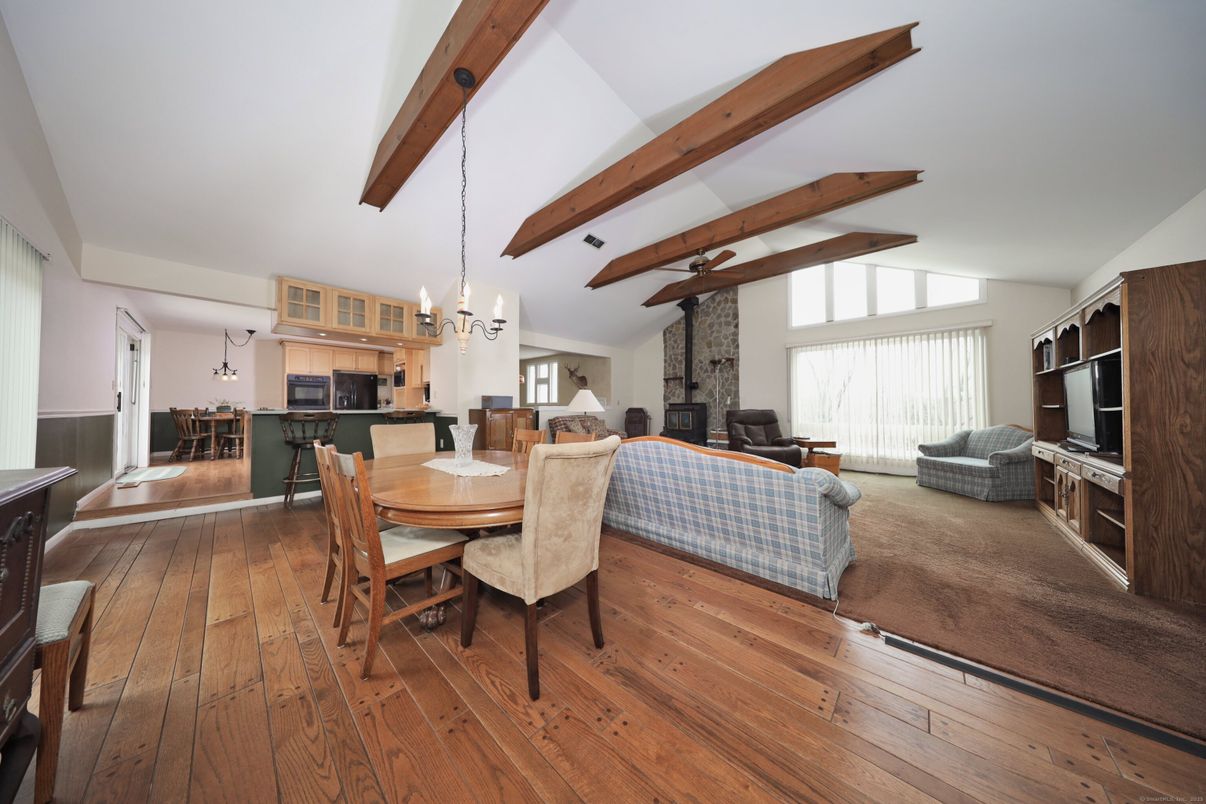 Chandelier, Dining room, Fireplace, Interior, Kitchen, Living room, Pendant Lights, Stainless Steel Appliances, Stone Walls, Wooden Beams, Wood Texture Flooring