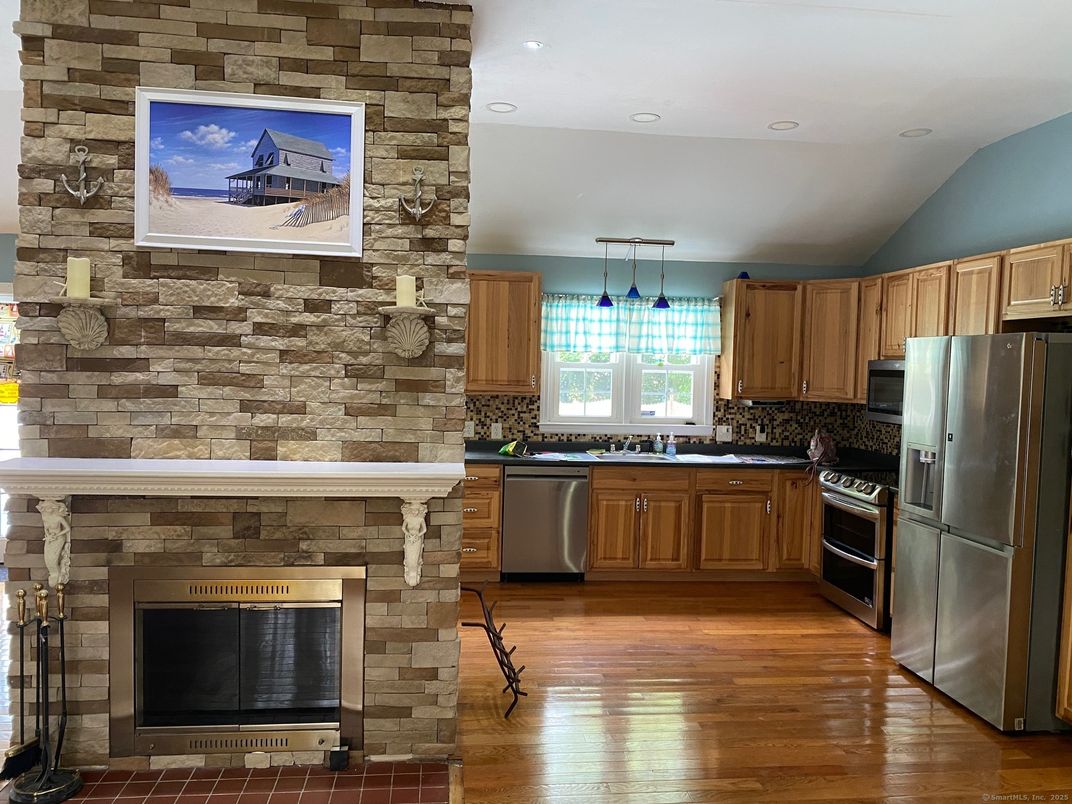 Fireplace, Interior, Kitchen, Pendant Lights, Recessed Lighting, Stainless Steel Appliances, Stone Walls, Wood Texture Flooring