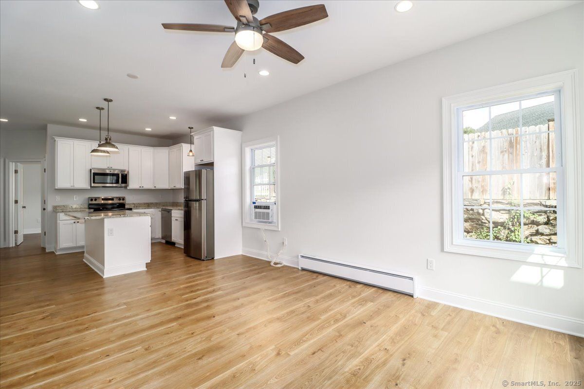 Empty room, Interior, Kitchen, Pendant Lights, Recessed Lighting, Stainless Steel Appliances, Wood Texture Flooring