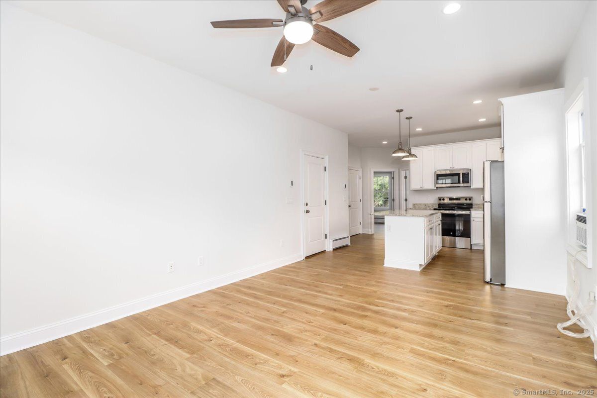 Empty room, Interior, Kitchen, Pendant Lights, Recessed Lighting, Stainless Steel Appliances, Wood Texture Flooring