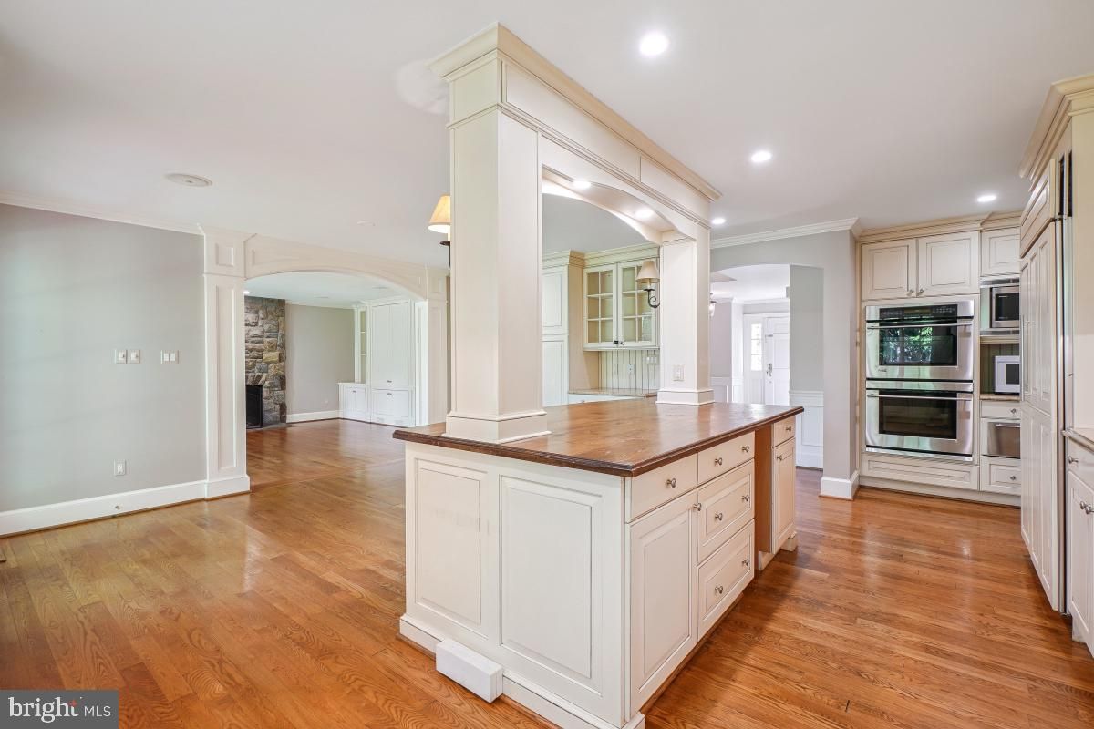 Empty room, Fireplace, Interior, Kitchen, Recessed Lighting, Stainless Steel Appliances, Wood Texture Flooring