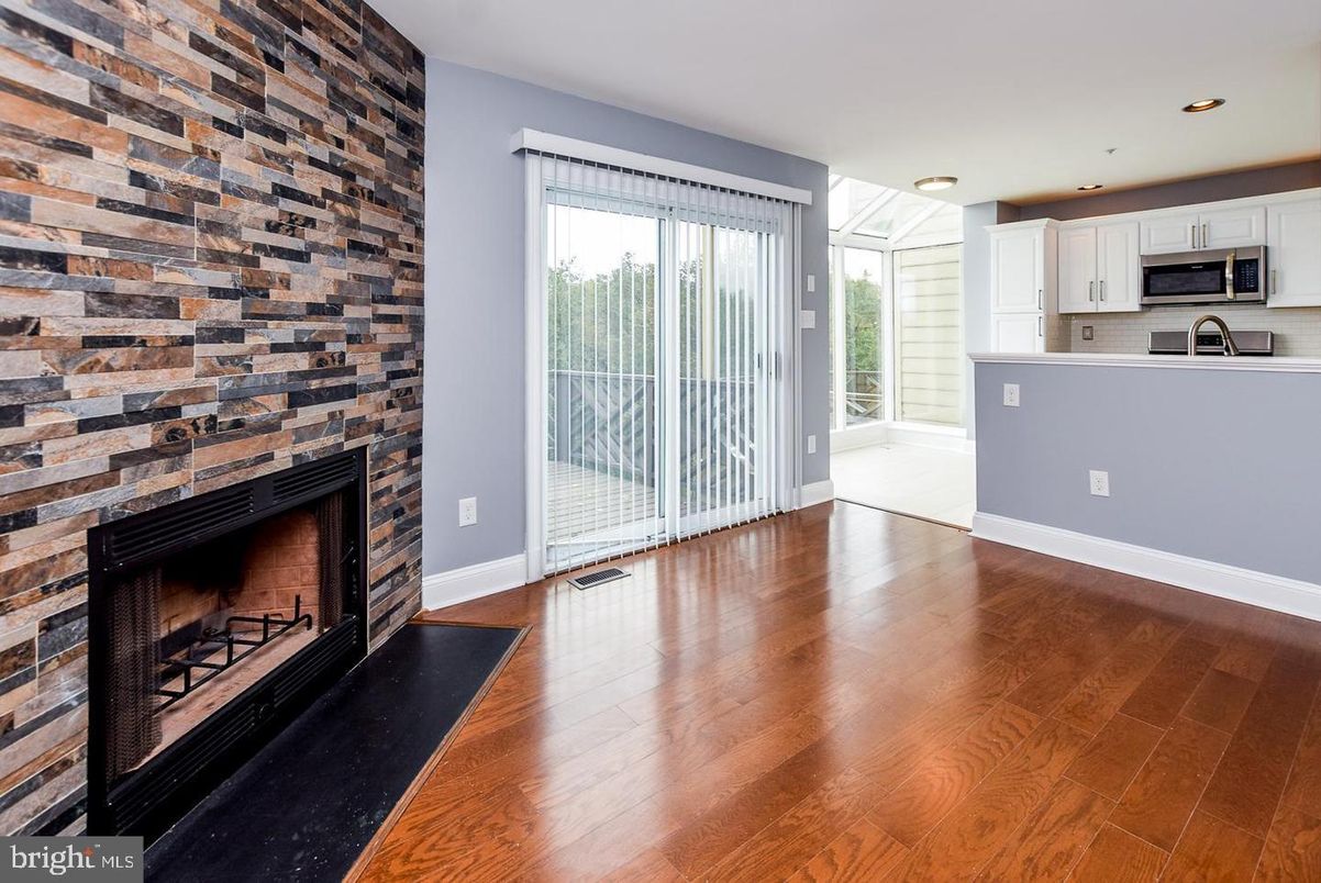 Empty room, Fireplace, Interior, Kitchen, Recessed Lighting, Stainless Steel Appliances, Stone Walls, Wood Texture Flooring