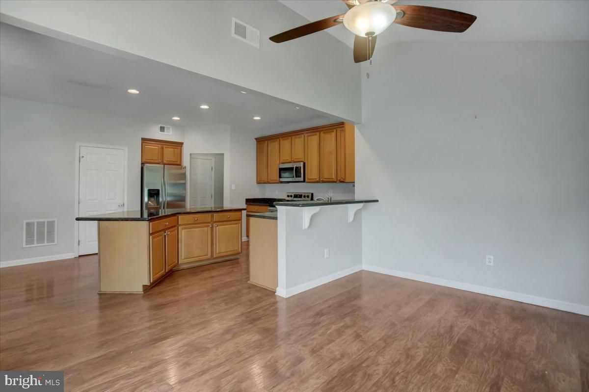 Empty room, Interior, Kitchen, Recessed Lighting, Stainless Steel Appliances, Wood Texture Flooring