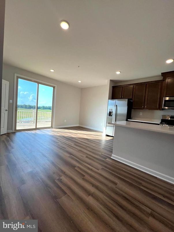 Empty room, Interior, Kitchen, Recessed Lighting, Stainless Steel Appliances, Wood Texture Flooring