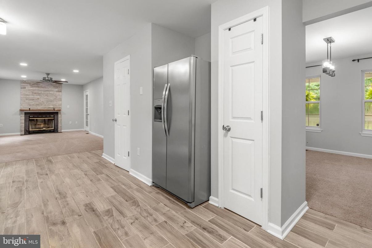 Empty room, Fireplace, Interior, Kitchen, Pendant Lights, Recessed Lighting, Stainless Steel Appliances, Stone Walls, Wood Texture Flooring