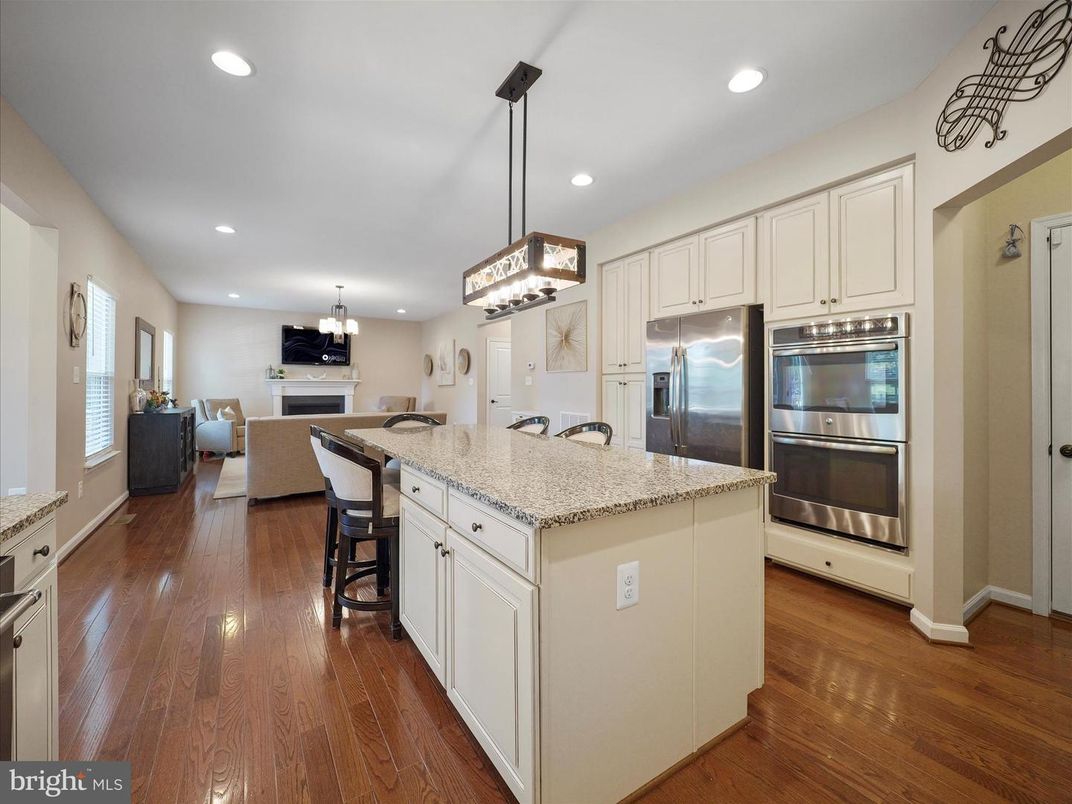Chandelier, Dining room, Fireplace, Interior, Kitchen, Living room, Pendant Lights, Recessed Lighting, Stainless Steel Appliances, Wood Texture Flooring