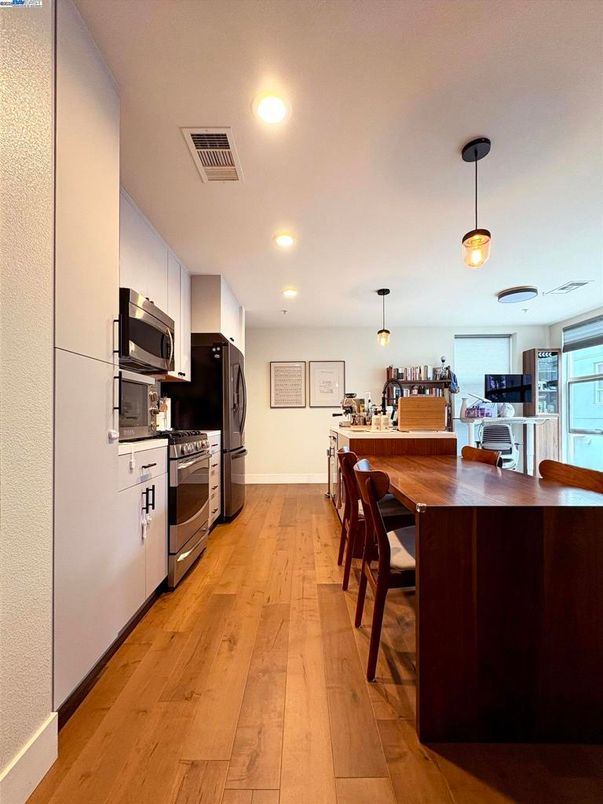 Dining room, Interior, Kitchen, Pendant Lights, Recessed Lighting, Stainless Steel Appliances, Wood Texture Flooring