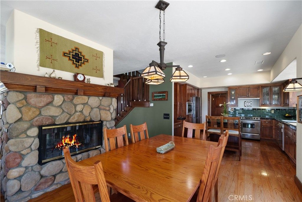 Dining room, Fireplace, Interior, Kitchen, Pendant Lights, Recessed Lighting, Stainless Steel Appliances, Stone Walls, Wood Texture Flooring