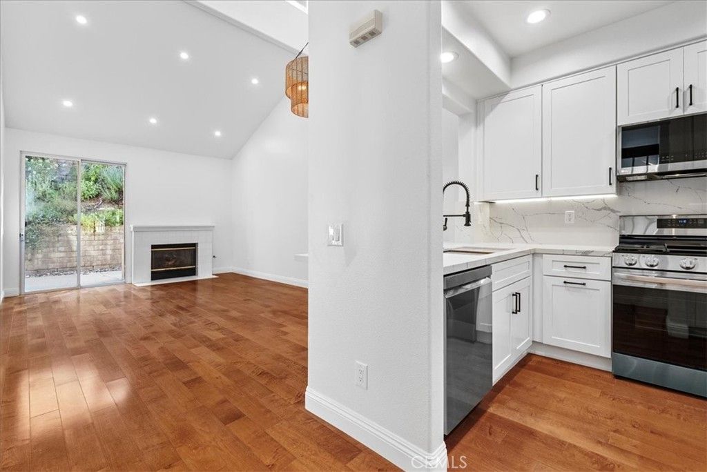 Fireplace, Interior, Kitchen, Recessed Lighting, Stainless Steel Appliances, Wood Texture Flooring