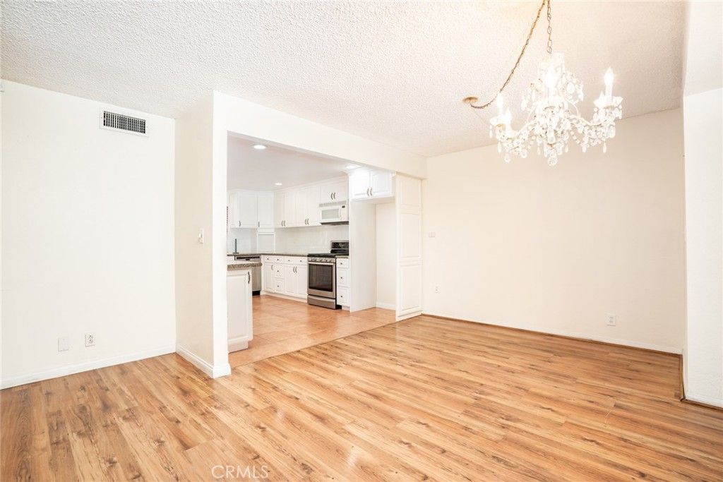 Chandelier, Empty room, Interior, Kitchen, Recessed Lighting, Stainless Steel Appliances, Wood Texture Flooring