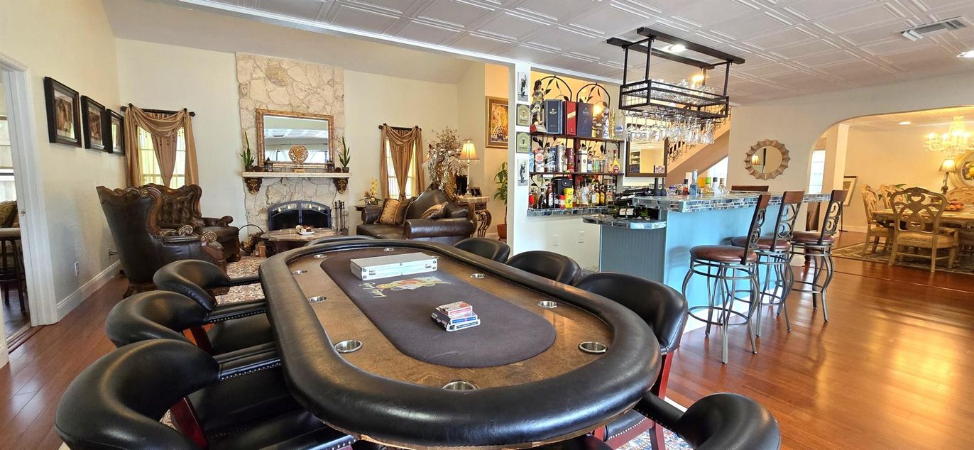Chandelier, Dining room, Fireplace, Game Room, Interior, Stone Walls, Wood Texture Flooring