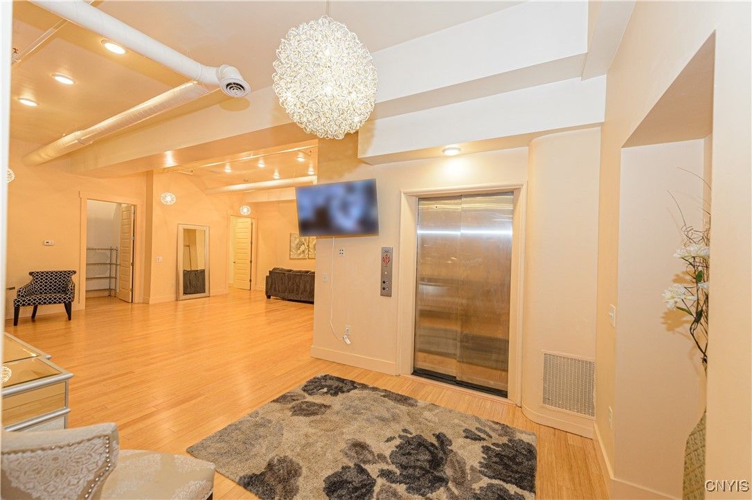 Chandelier, Elevator, Interior, Recessed Lighting, Wood Texture Flooring