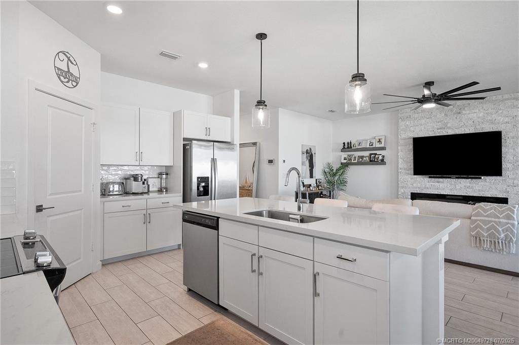 Fireplace, Interior, Kitchen, Pendant Lights, Recessed Lighting, Stainless Steel Appliances, Stone Walls, Wood Texture Flooring
