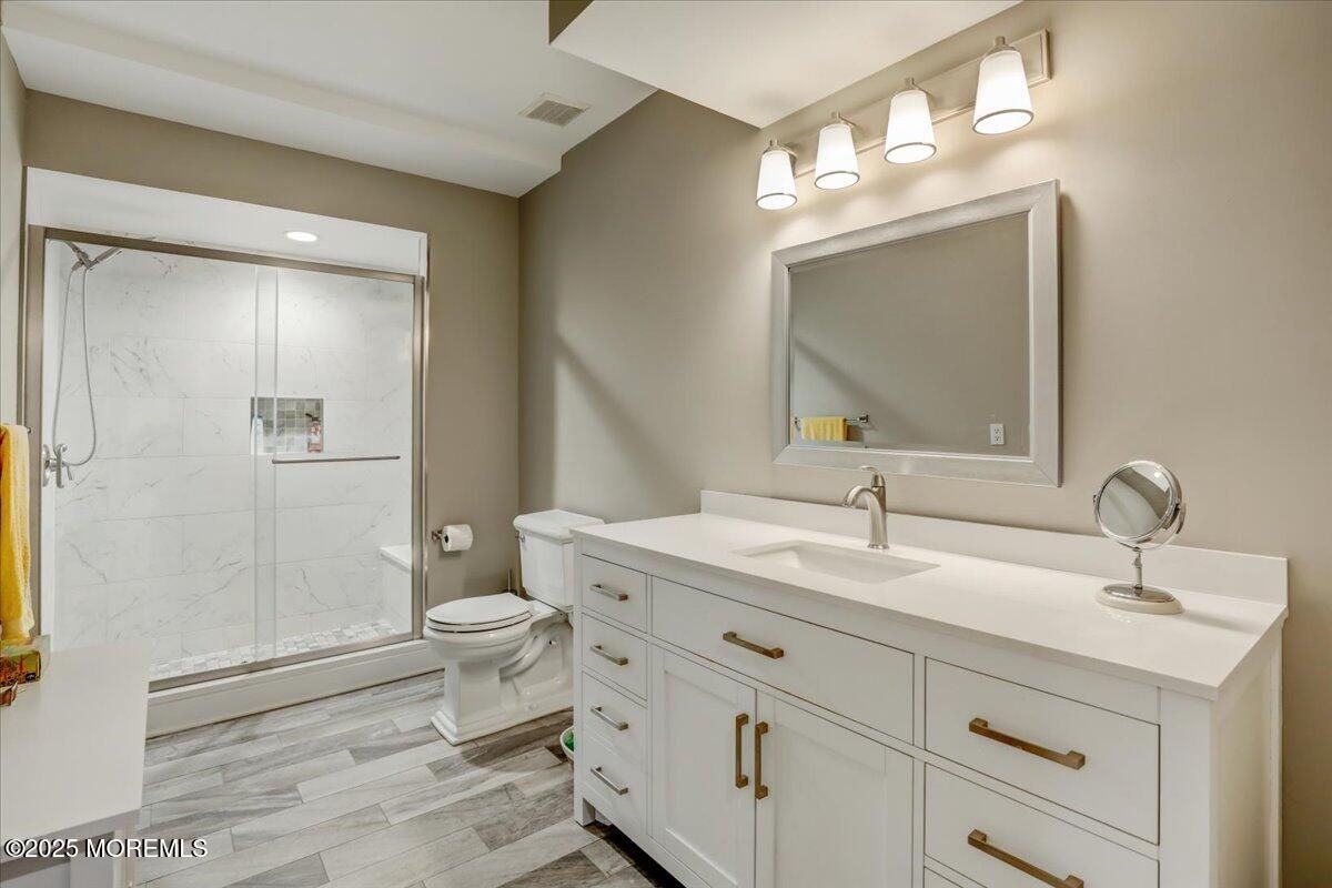 Bathroom, Dual Sink Vanities, Glass Shower, Interior, Marble Walls, Recessed Lighting, Wood Texture Flooring