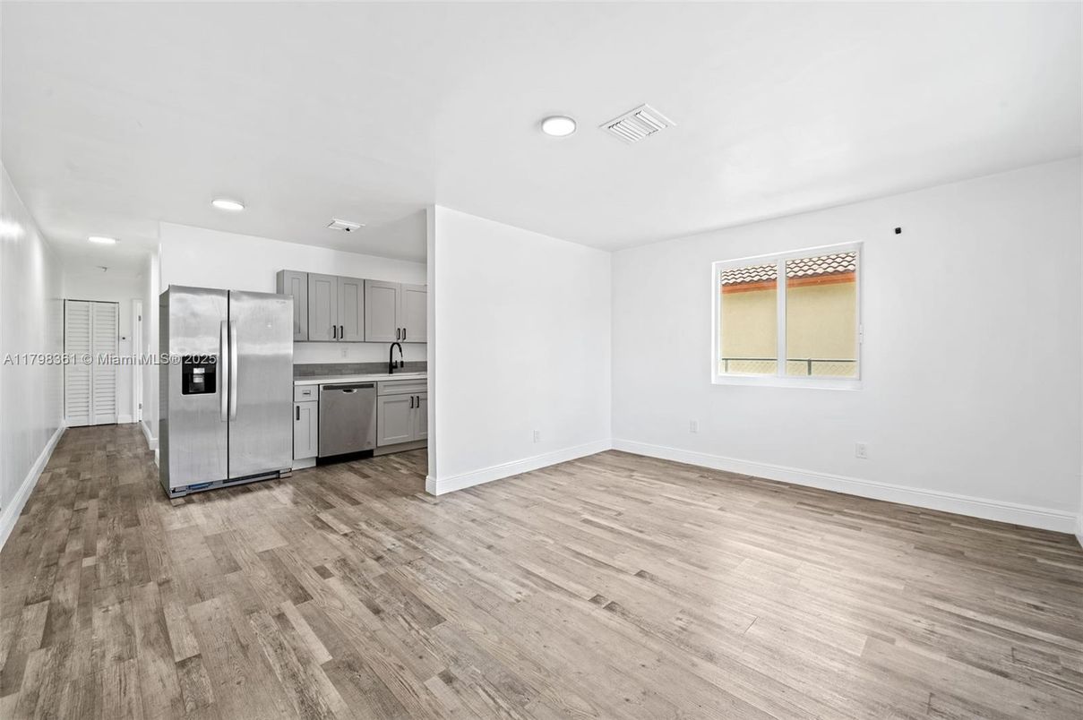 Empty room, Interior, Kitchen, Recessed Lighting, Stainless Steel Appliances, Wood Texture Flooring