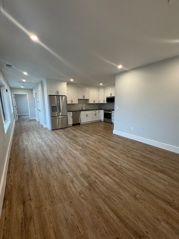 Empty room, Interior, Kitchen, Recessed Lighting, Stainless Steel Appliances, Wood Texture Flooring