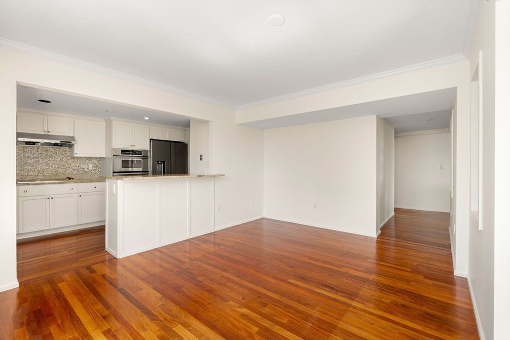 Empty room, Interior, Kitchen, Recessed Lighting, Stainless Steel Appliances, Wood Texture Flooring