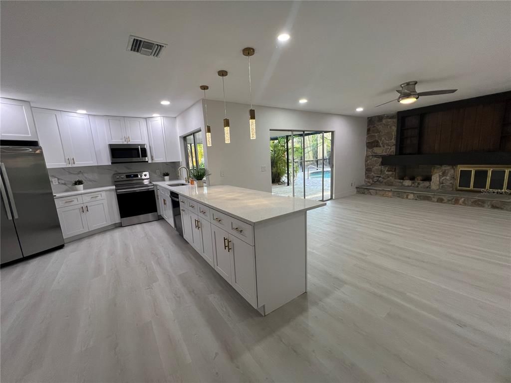 Interior, Kitchen, Pendant Lights, Recessed Lighting, Stainless Steel Appliances, Stone Walls, Wood Texture Flooring