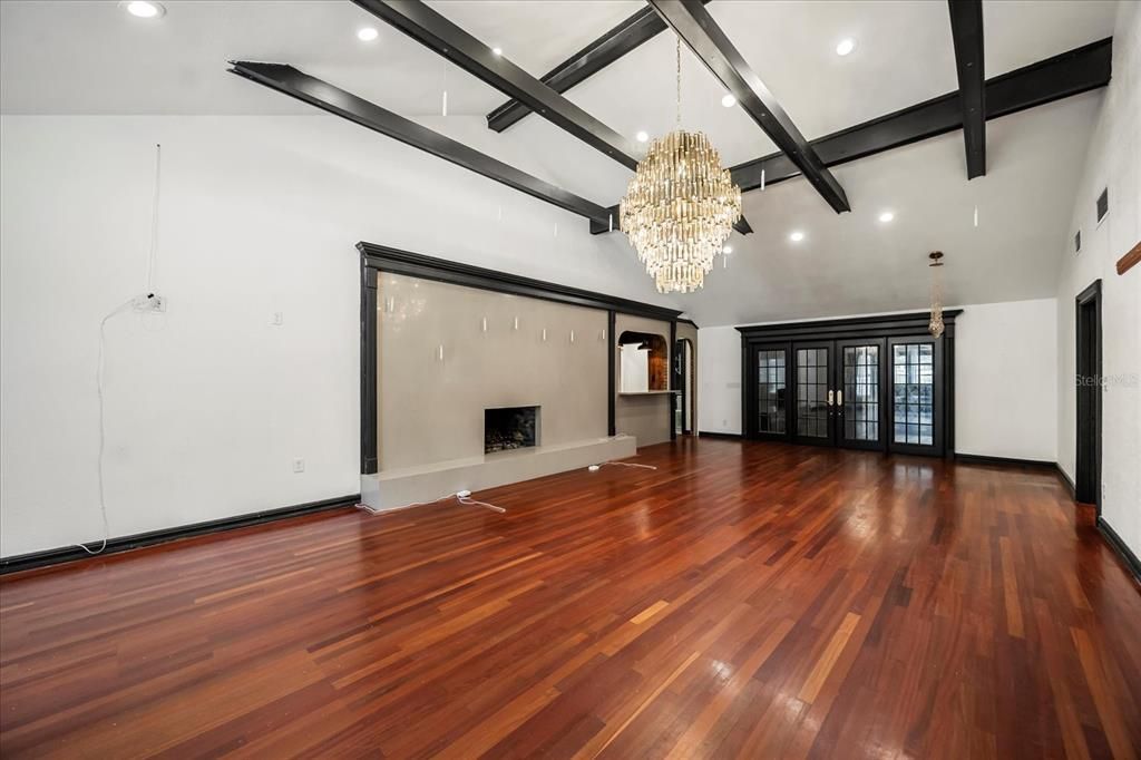 Chandelier, Empty room, Fireplace, Interior, Recessed Lighting, Wooden Beams, Wood Texture Flooring