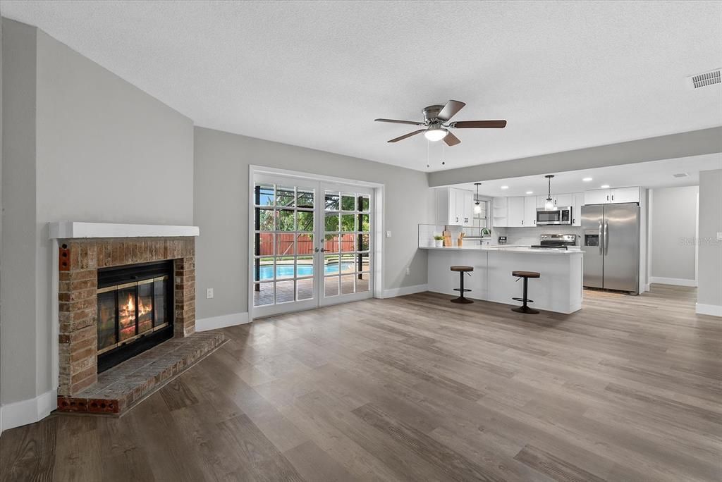 Empty room, Fireplace, Interior, Kitchen, Pendant Lights, Recessed Lighting, Stainless Steel Appliances, Wood Texture Flooring