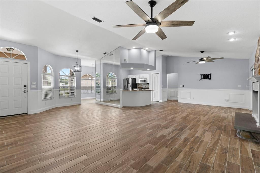 Empty room, Fireplace, Interior, Kitchen, Pendant Lights, Recessed Lighting, Stainless Steel Appliances, Wood Texture Flooring