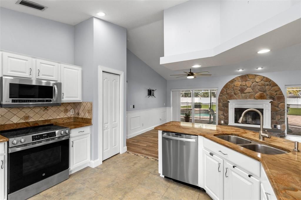 Fireplace, Interior, Kitchen, Recessed Lighting, Stainless Steel Appliances, Stone Walls, Wood Texture Flooring