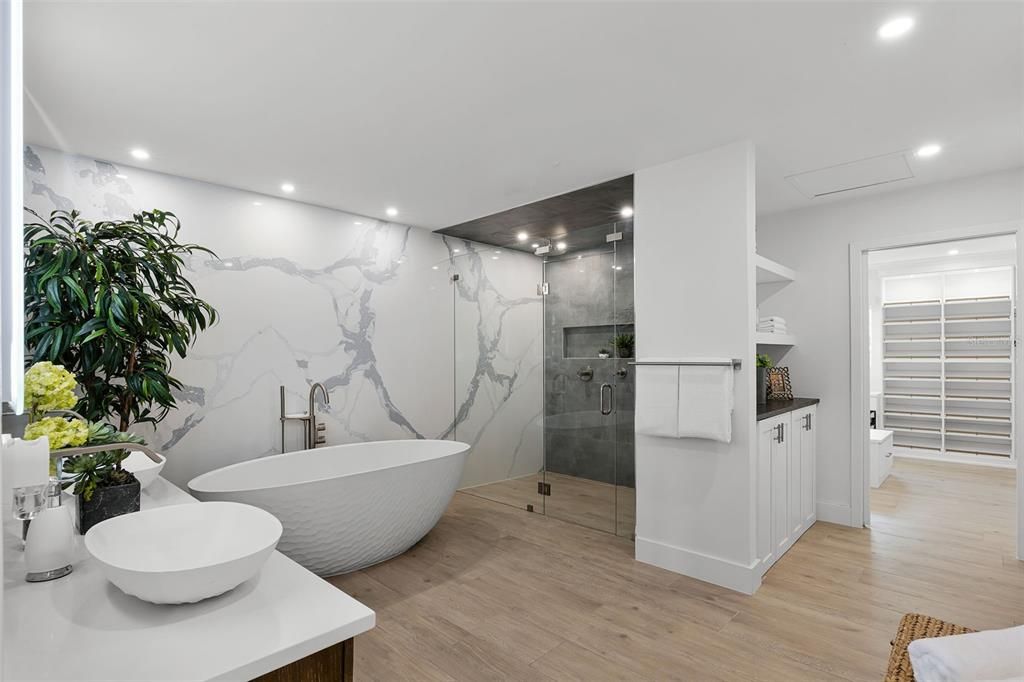 Bathroom, Dual Sink Vanities, Free Standing Baths, Glass Shower, Interior, Marble Walls, Recessed Lighting, Wood Texture Flooring