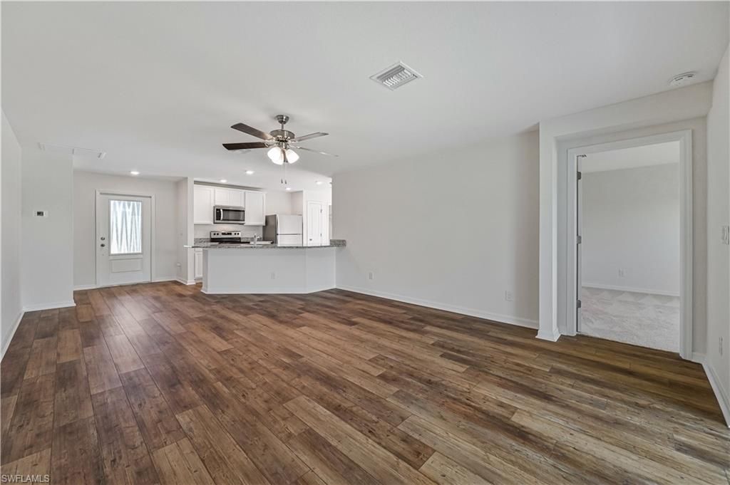 Empty room, Interior, Kitchen, Recessed Lighting, Stainless Steel Appliances, Wood Texture Flooring