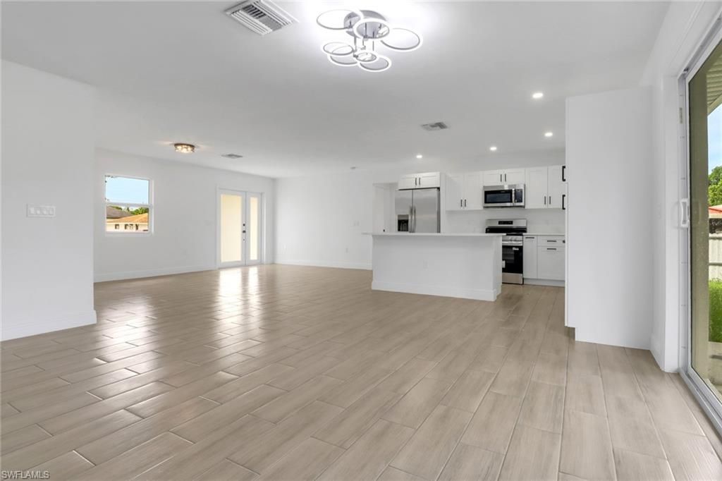 Empty room, Interior, Kitchen, Pendant Lights, Recessed Lighting, Stainless Steel Appliances, Wood Texture Flooring