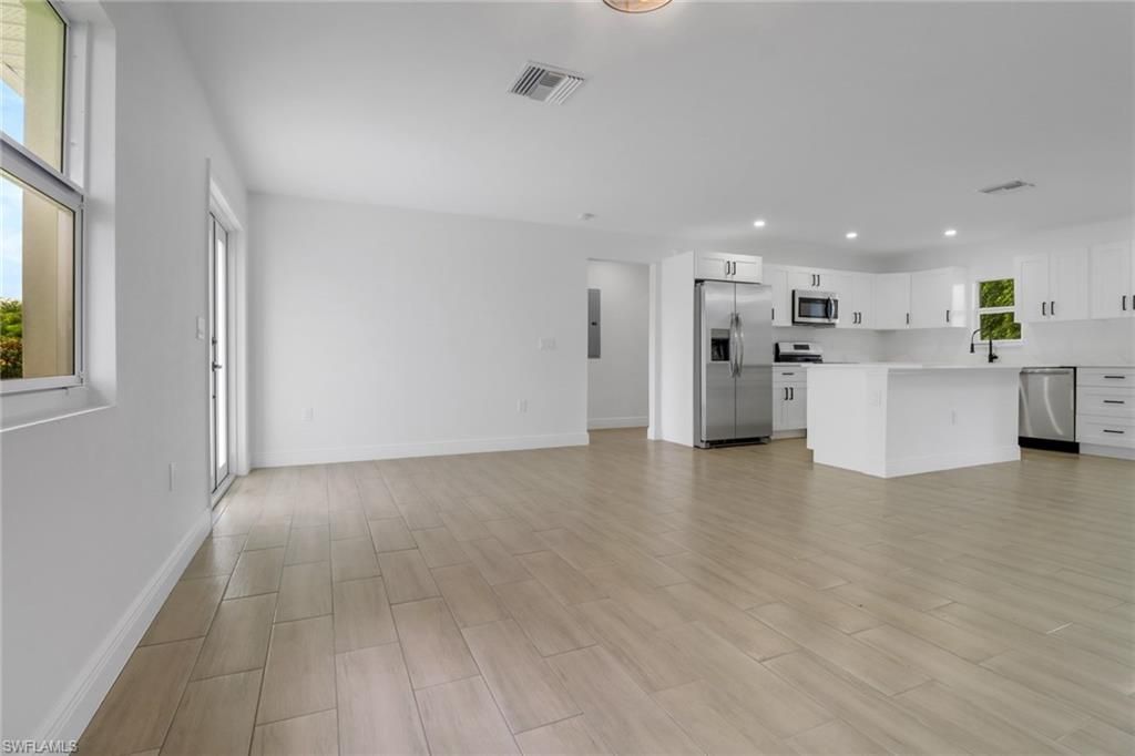 Empty room, Interior, Kitchen, Recessed Lighting, Stainless Steel Appliances, Wood Texture Flooring