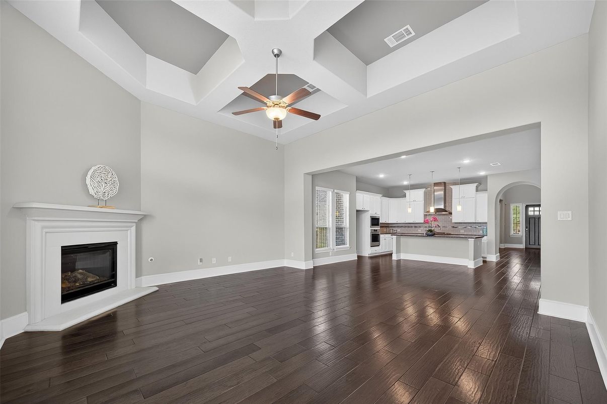 Empty room, Fireplace, Interior, Kitchen, Pendant Lights, Recessed Lighting, Stainless Steel Appliances, Wood Texture Flooring