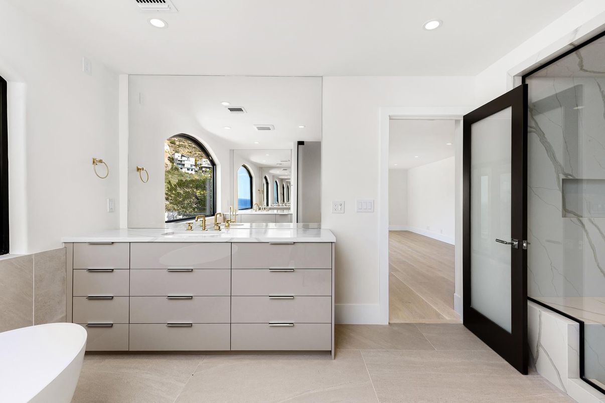 Bathroom, Dual Sink Vanities, Free Standing Baths, Glass Shower, Interior, Marble Walls, Recessed Lighting, Wood Texture Flooring