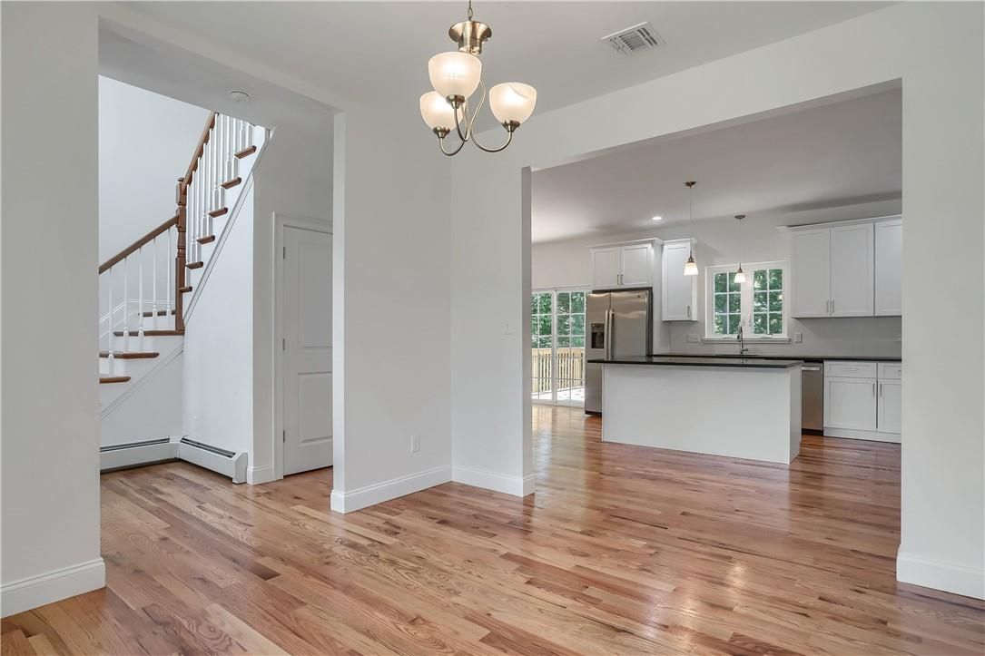Chandelier, Empty room, Interior, Kitchen, Pendant Lights, Recessed Lighting, Stainless Steel Appliances, Wood Texture Flooring