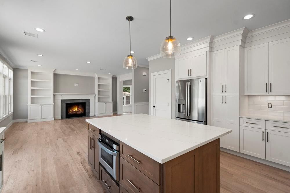 Empty room, Fireplace, Interior, Kitchen, Pendant Lights, Recessed Lighting, Stainless Steel Appliances, Wood Texture Flooring