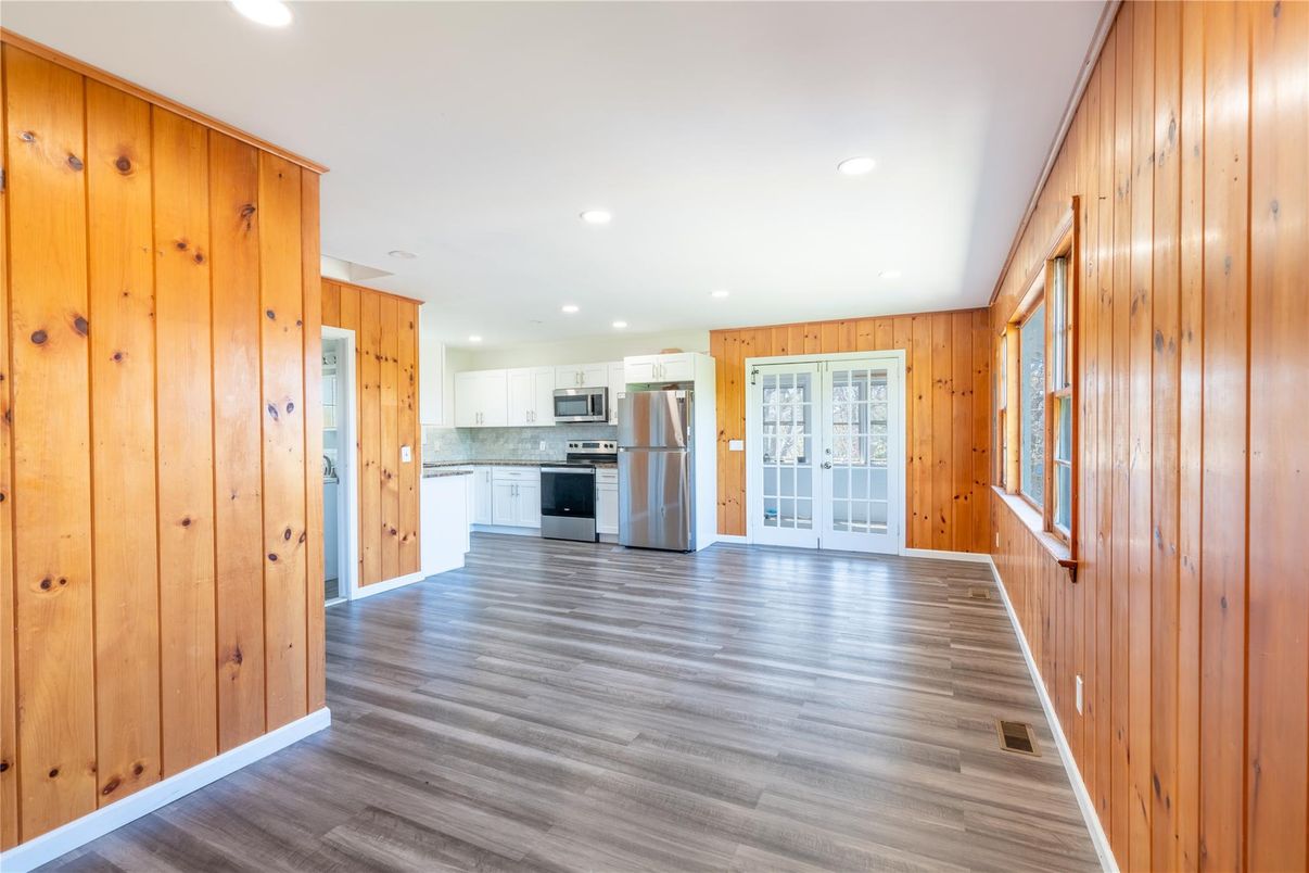 Empty room, Interior, Kitchen, Recessed Lighting, Stainless Steel Appliances, Wood Texture Flooring, Wooden Walls