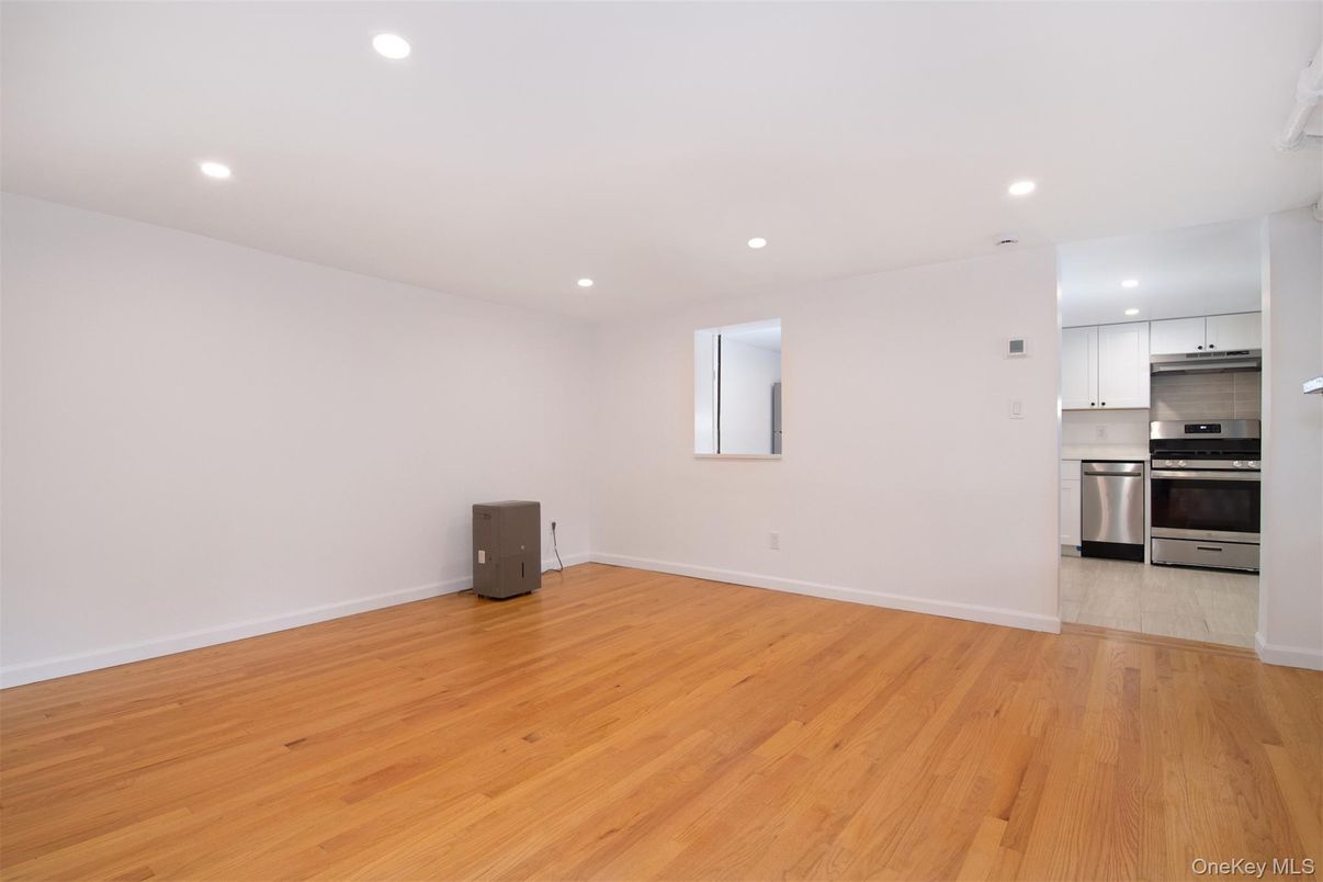 Empty room, Interior, Kitchen, Recessed Lighting, Stainless Steel Appliances, Wood Texture Flooring